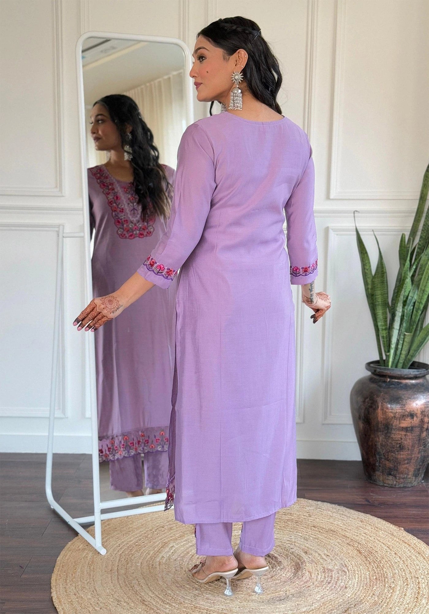 Woman in a lavender traditional outfit standing in front of a mirror.